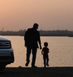 silhouette of man and child near white hyundai tucson suv during golden hour